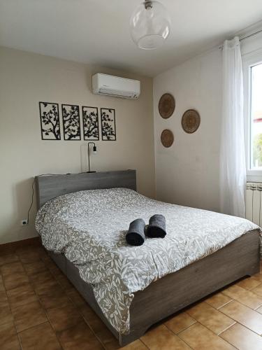 a bedroom with a bed with two hats on it at Maison 6 pers, avec jardin, clim et pétanque in Thuir