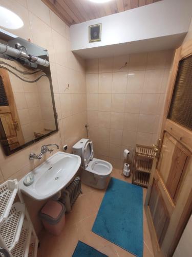 a bathroom with a sink and a toilet and a mirror at Domek Letniskowy - Jerutki in Jerutki