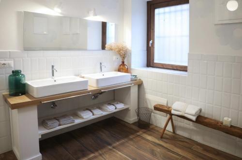 a bathroom with two sinks and towels on a shelf at Museo Grillo Camere d'Arte, dormire nel Museo in Arena Po