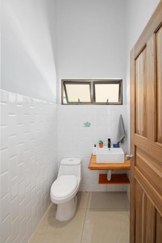 Un baño blanco con inodoro y lavabo. en Cabina El Titi, 3Min from the Beach! Playa Chiquita, en Punta Uva