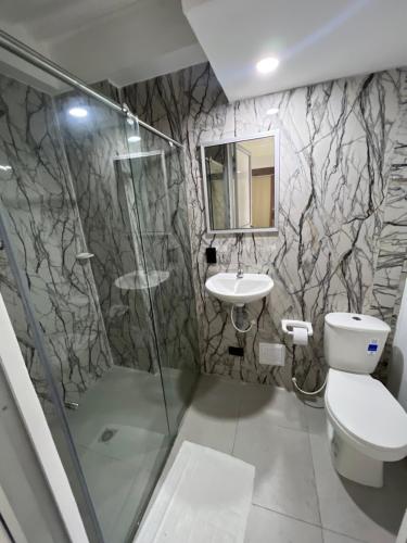 a bathroom with a shower and a toilet and a sink at Hotel Boutique Santa Ana in Cartago