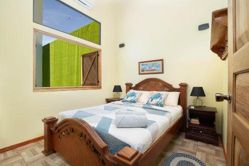 a bedroom with a bed and a window at Cabinas Sede Villalobos, 3Min from the Beach! Playa Chiquita in Punta Uva