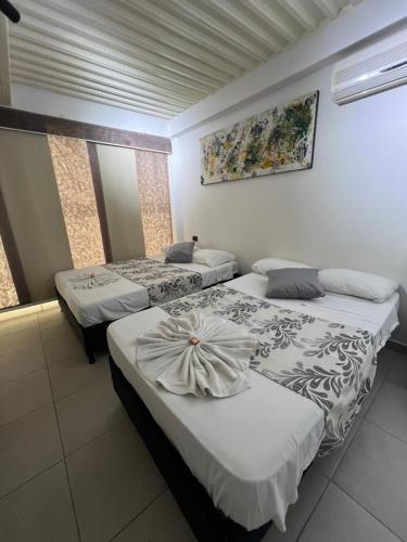a room with three beds in a room at Hotel Boutique Santa Ana in Cartago