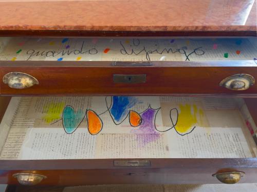 a wooden drawer with stained glass papers in it at Museo Grillo Camere d'Arte, dormire nel Museo in Arena Po