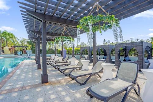 a row of chairs next to a swimming pool at Sunny Summer Awaits - Renovated Townhome by Disney! in Orlando