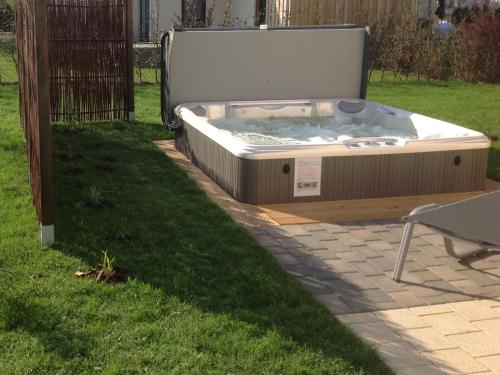 ゲーレン・レビンにあるLuxus FH "Seekiste" mit 38C Außenwhirlpoolの庭の芝生に座ったホットタブ