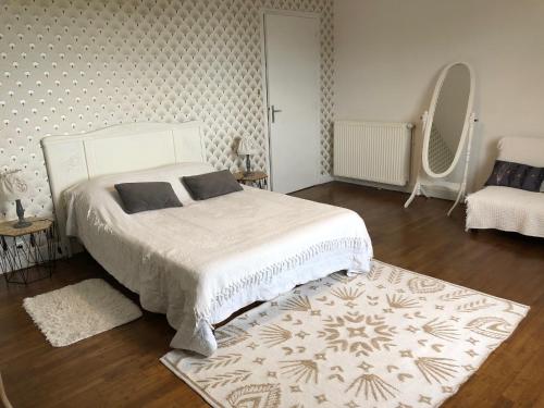 - une chambre avec un lit blanc et un tapis dans l'établissement Gîte de Chavagnac, à Saint-Cyr-les-Champagnes