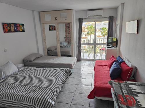 salon z dwoma łóżkami i kanapą w obiekcie Minerva Apartments Sea View w mieście Benalmádena
