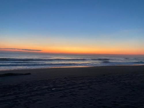 a sunset on a beach with the ocean at Cabañas y Restaurante La Luna in Boca del cielo
