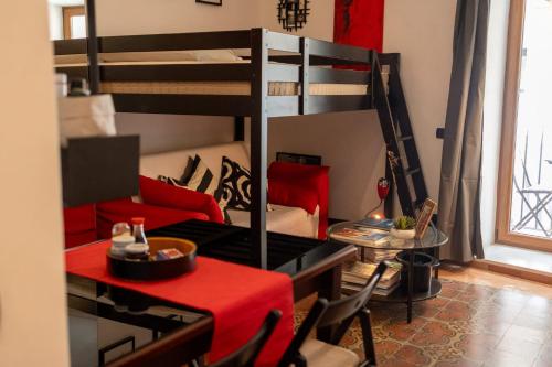 切法卢La Casa di Giò的客房设有两张双层床、一张桌子和一张沙发。