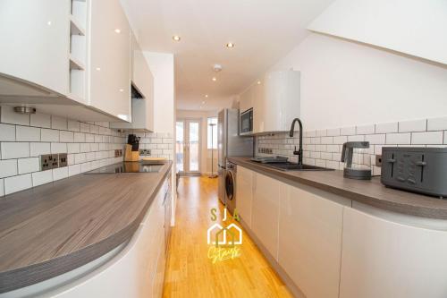 a kitchen with white cabinets and a wooden floor at Affleck Retreat 3 - SJA Stays - Modern 1 Bed Apartment in Aberdeen