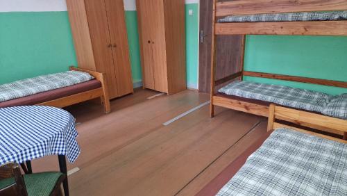 a room with two bunk beds and a table at Chata zelená in Jelenec