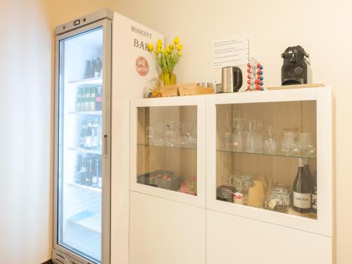 a white cabinet with glass doors in a kitchen at Hotel Kristoffel - Ontbijt inbegrepen in Middelkerke