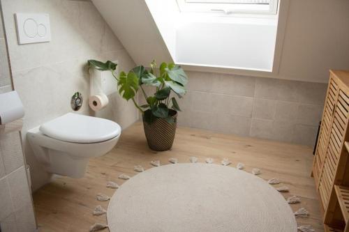 a bathroom with a toilet and a white rug at Ferienwohnung Kurz "Panoramablick" in Wertheim