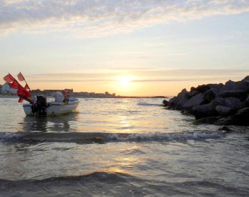 a small boat in the water at sunset at Muschelkoje in Schönberg