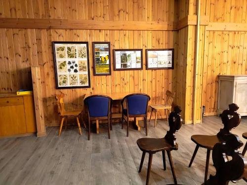 a room with a table and chairs and pictures on the wall at Appartaments Lavaredo in Carbonin
