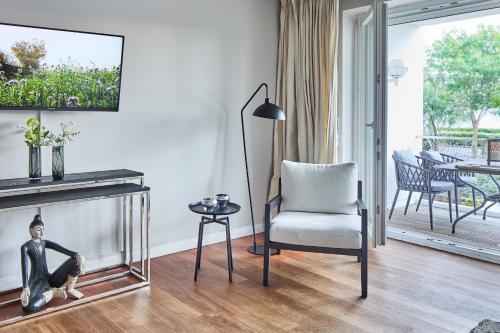 a living room with a chair and a table at Techts Apartmenthaus in Timmendorfer Strand