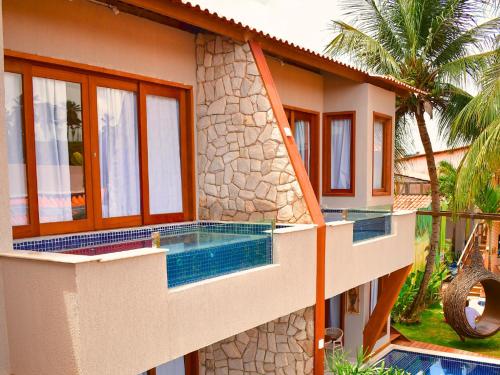 una casa con piscina delante en Pousada Sol e Mar, en Maragogi