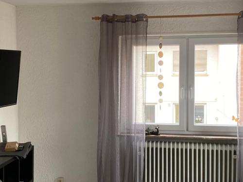 une fenêtre avec des rideaux et un radiateur dans une pièce dans l'établissement Apartment und Ferienwohnung Mackenbach 2, à Mackenbach