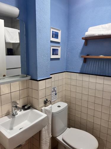 a bathroom with a white toilet and a sink at Hostal La Lluna in Arenys de Mar