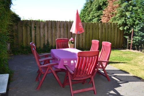 a table with four chairs and an umbrella on a patio at Wohnung "Venedig" in Heede