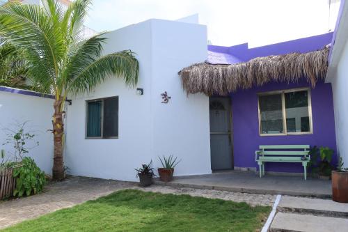 a purple and white house with a palm tree at Casa Cebra by the beach -Roof top lounge! Playa del Niño in Cancún