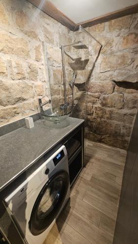 Appartement vue imprenable montagne في Serra-di-Scopamene: غسالة ملابس مع وعاء فوقها في الحمام