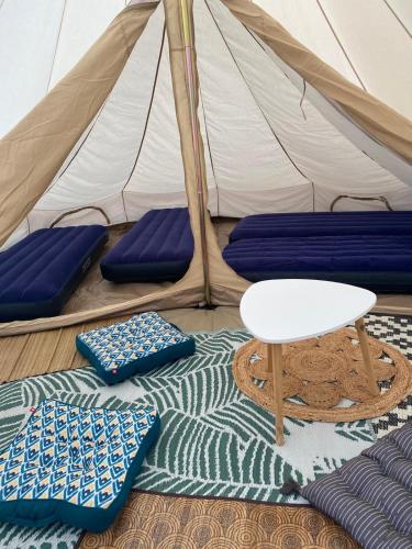 une tente avec deux oreillers et une table à l'avant dans l'établissement Glamping Sainte Suzanne, à Sainte-Suzanne