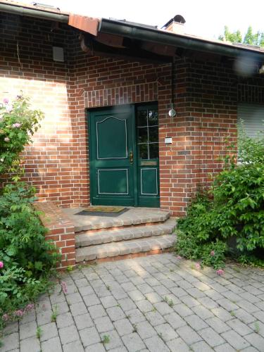 a brick house with a green door and stairs at Helle 1Obergeschosswohnung OG in Möhnesee