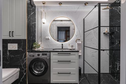 a bathroom with a washing machine and a mirror at Apartament Berry in Waksmund