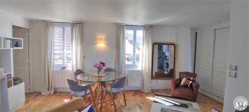 un salon avec une table en verre et des chaises dans l'établissement L'appart, à Compiègne