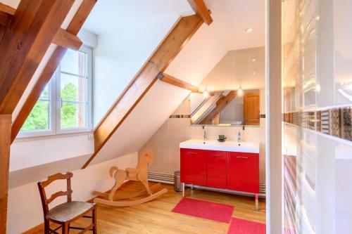 - une cuisine mansardée avec une armoire rouge dans l'établissement La rainvilloise gite de rainvillers, à Rainvillers