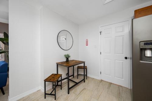 a hallway with a table and a mirror on a wall at The Perfect Family Retreat w Pool and Games in West Chase