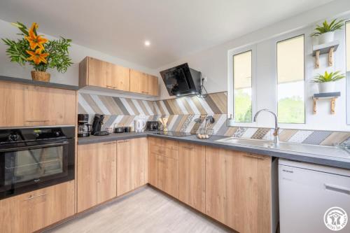 une cuisine avec des armoires en bois et un évier dans l'établissement Nou kontan vwe-zot, à Abbecourt