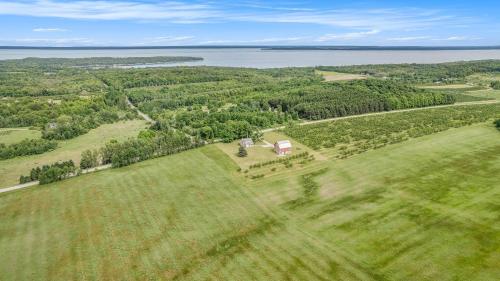 een luchtfoto van een huis in een veld met het water bij Historic 5BDR Orchard Home in Suttons Bay
