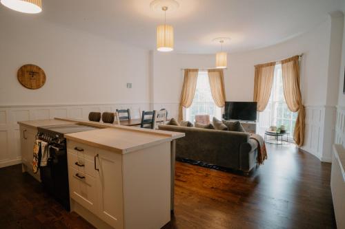 a kitchen and living room with a couch and a table at Slateford House 1770 Luxury Aparthotel by The House of Danu in Edinburgh