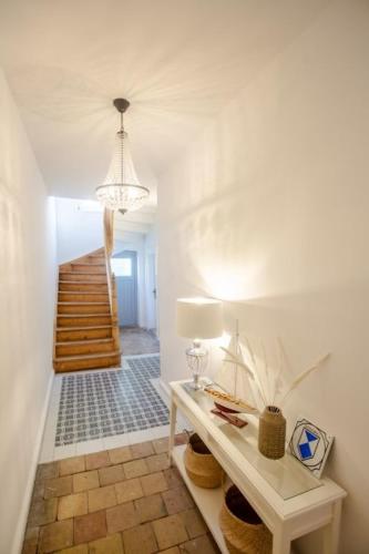 a hallway with a table with a lamp and stairs at Apartment No6 in Stralsund