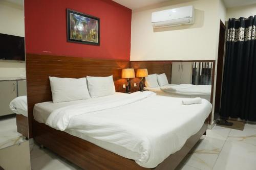 a bedroom with a large bed and a red wall at hotel Elites Residency , iqbal town in Lahore