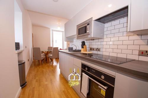 a kitchen with a sink and a counter top at Affleck Stay 2 - SJA Stays - Modern 2 Bed Apartment in Aberdeen