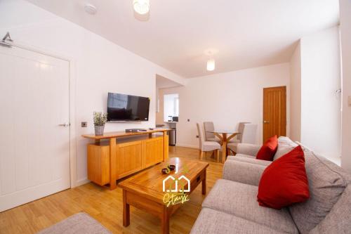 a living room with a couch and a tv at Affleck Stay 2 - SJA Stays - Modern 2 Bed Apartment in Aberdeen