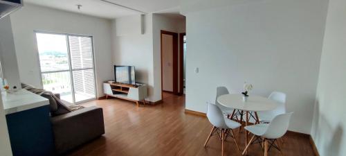 a living room with a table and chairs and a television at Comforto a Beira-Mar com Vista Deslumbrante in Barra Velha