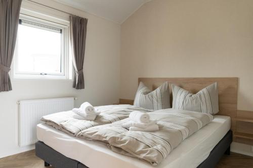ein Schlafzimmer mit einem großen Bett mit Handtüchern darauf in der Unterkunft Chalet bis sechs Personen ohne Hund - a61188 in Norden