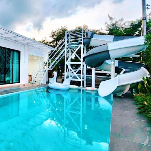 a swimming pool with a water slide in a house at Colmar PoolVilla Khao Yai in Wangkata