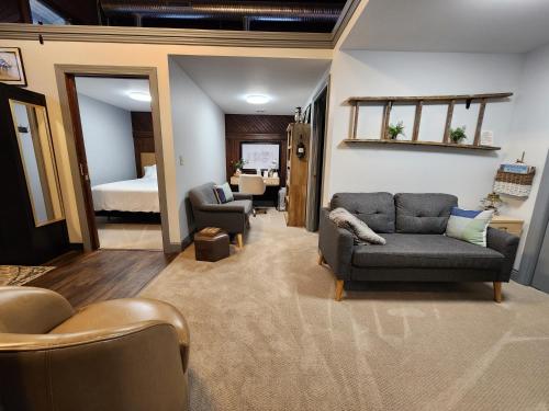 a living room with a couch and chairs and a bed at Historic Springville Train Depot Inn Hotel Apartment in Springville
