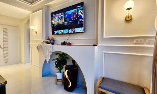 a living room with a tv on a wall at Colmar PoolVilla Khao Yai in Wangkata