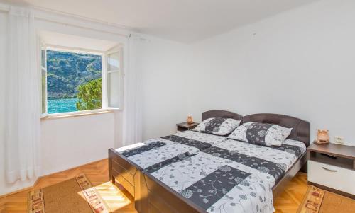 a bedroom with a bed and a window at Apartman Monkovic in Mokošica