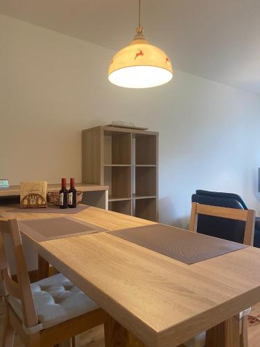 a dining room with a wooden table and a light fixture at Appartement Raineck in Mittenwald