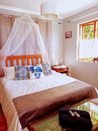 a bedroom with a bed with a mosquito net at Lavender Cottage in Cape Town