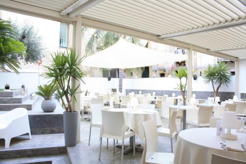 切法卢La Casa di Giò的一间设有白色桌子和白色椅子的餐厅