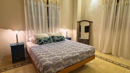 a bedroom with a large bed and a mirror at Casa Zarah - Alma Hotels in Santa Marta